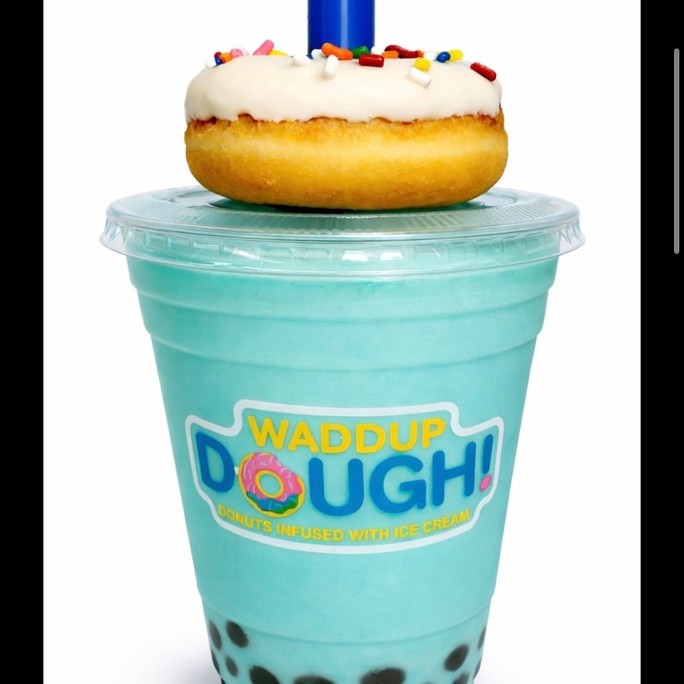 Blue Hawaii Boba Shake with a white-frosted, sprinkle-covered donut on top, and a blue straw.